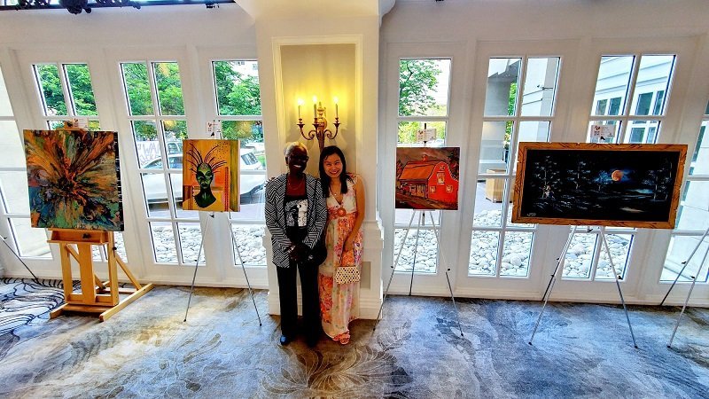 Elsa Robinson & Aeris Osborne stood besides that painting in The Works Summer Solstice Macdonald Fairmont Hotel